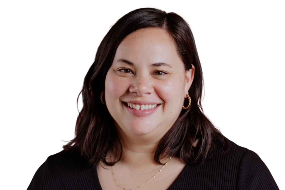 Woman with dark hair smiles, wearing gold hoop earrings and a black top, on a white background.