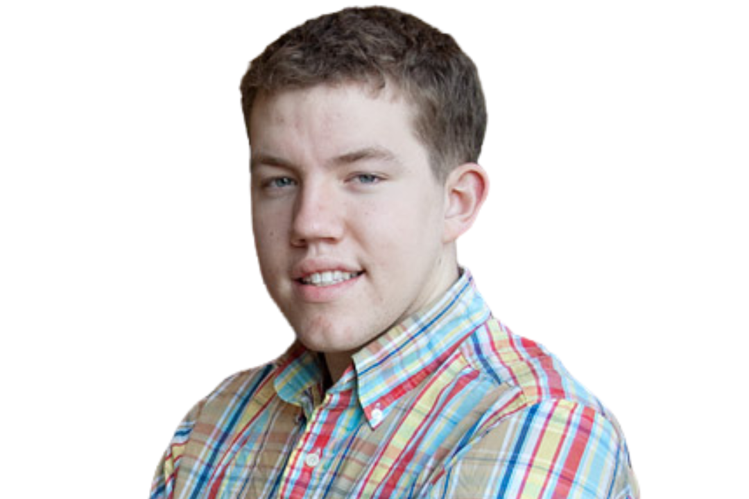 Young man wearing a colorful plaid shirt, smiling slightly, with a white background.