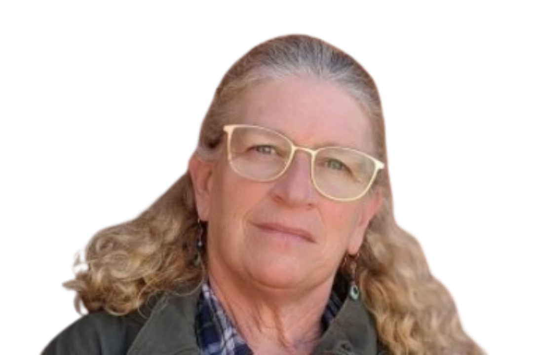 Woman with curly blonde hair, glasses, plaid shirt, and green jacket, facing forward, on a white background.