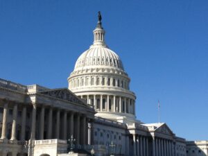 The white dome of the U.S. Capitol building against a clear blue sky.