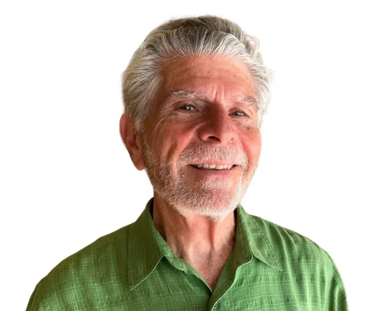 Smiling older man with gray hair and beard, wearing a green collared shirt, on a white background.